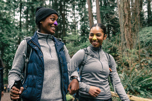 two people hiking through the woods wearing Nöz's reef safe Nözscreen