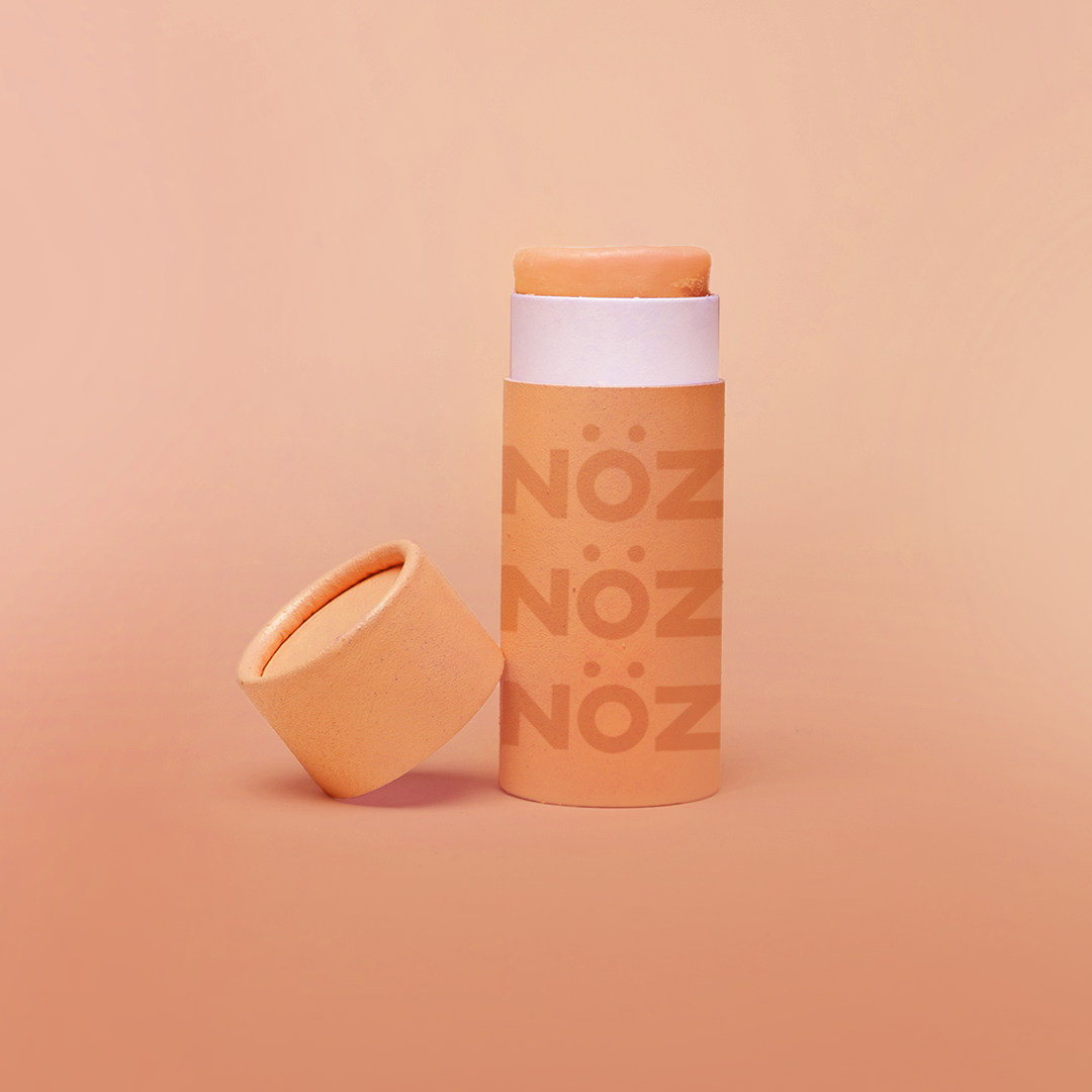 front view of orange creamsicle Nözscreen with the cap leaning on the product