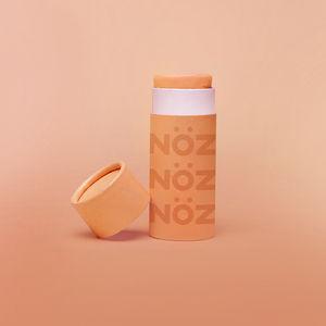 front view of orange creamsicle Nözscreen with the cap leaning on the product